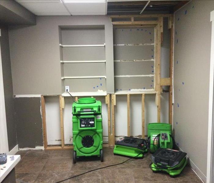 built in basement cabinets effected by water loss servpro green air movers and dehumidiers are drying the area
