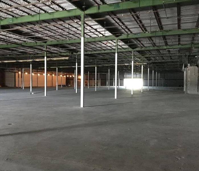 a large pre-construction store with exposed beams and cement floors 