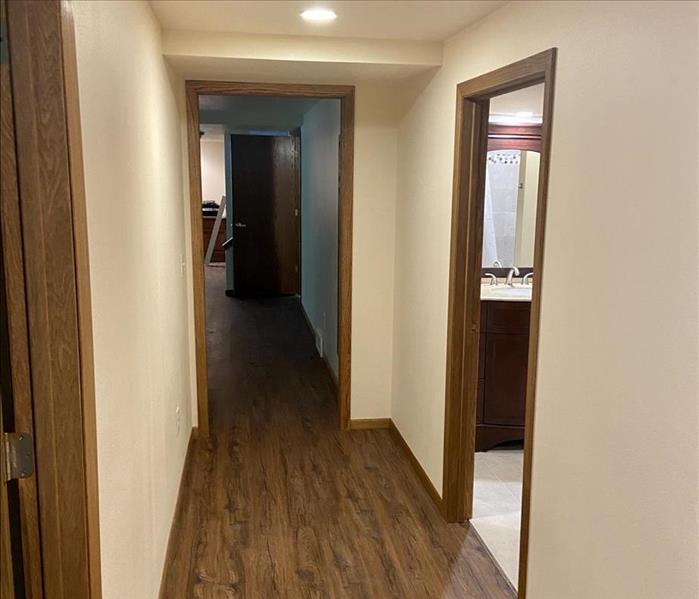 newly remodeled basement hallway with wood floors and freshly painted drywall and trim