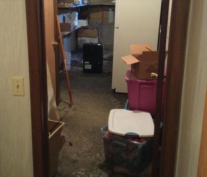 storage room in basement with scattered belongings from storm damage 