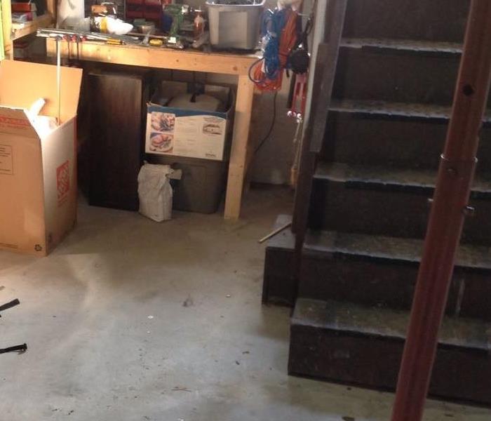 A dry basement with concrete floor and stairs on the right