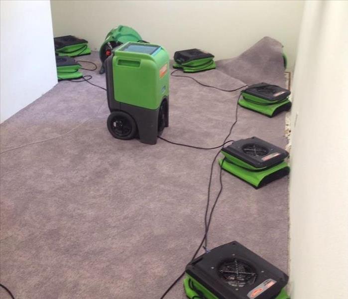 servpro drying fans and dehumidifiers drying out a basement from storm damage 