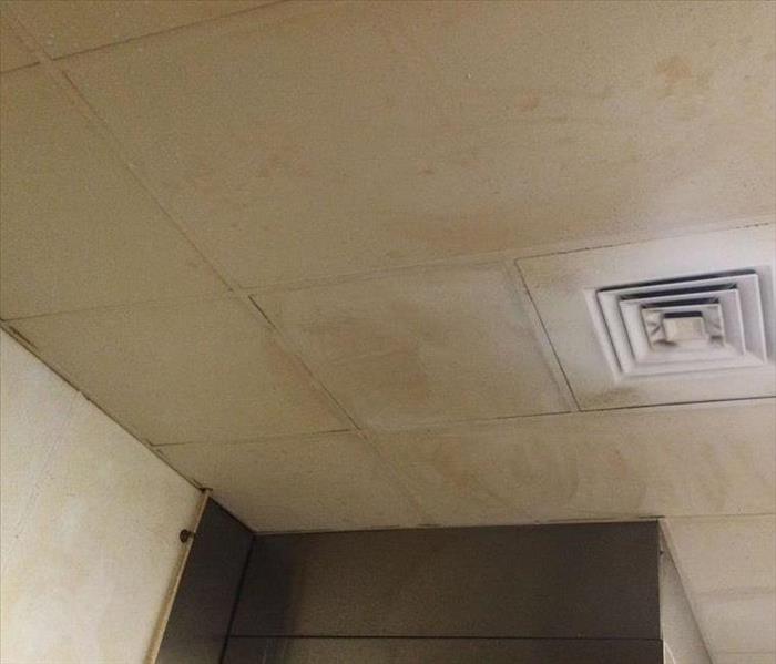 a ceiling of a restaurant with grease and food damage  