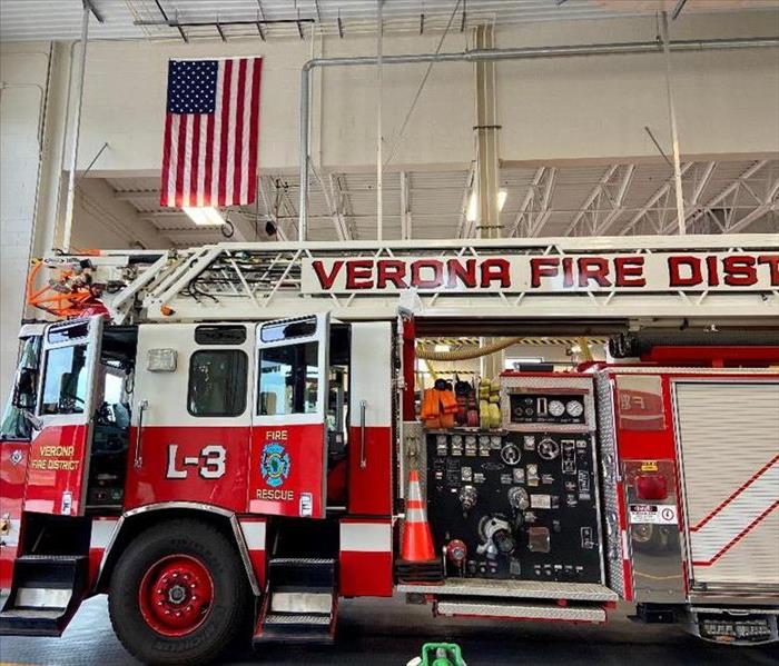Verona Fire truck with american flag behind it 