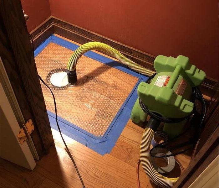 a bathroom toilet with SERVPRO floor mat drying system in place 