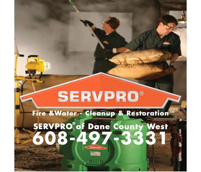 restoration technicians working on a fire damaged property with the servpro of dane county logo and phone number in front