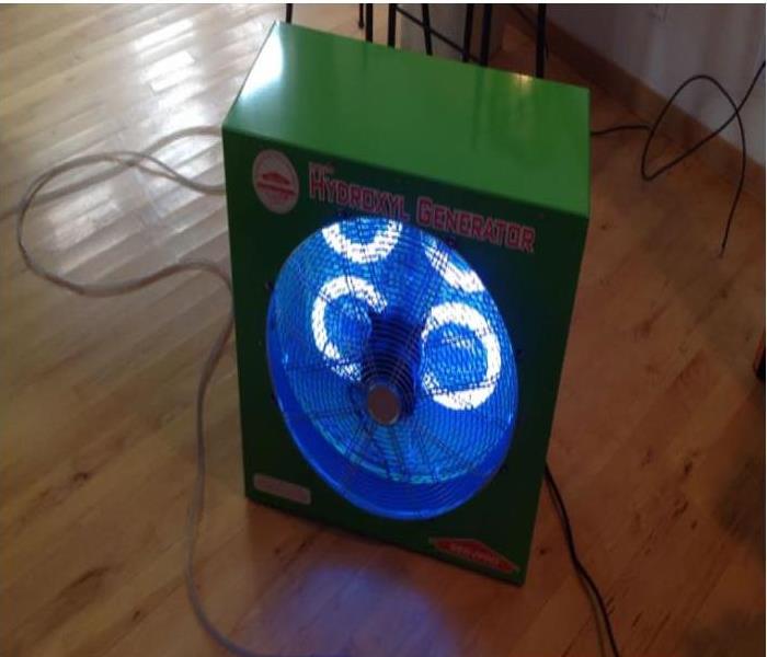a large green ozone machine with fans it has a blue led light indicating it is working 